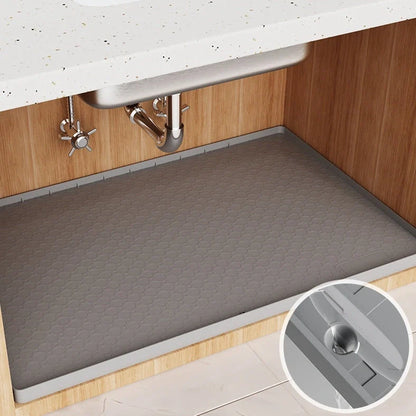 Grey silicone sink mat measuring 864mm by 558mm protecting kitchen cabinet from water damage