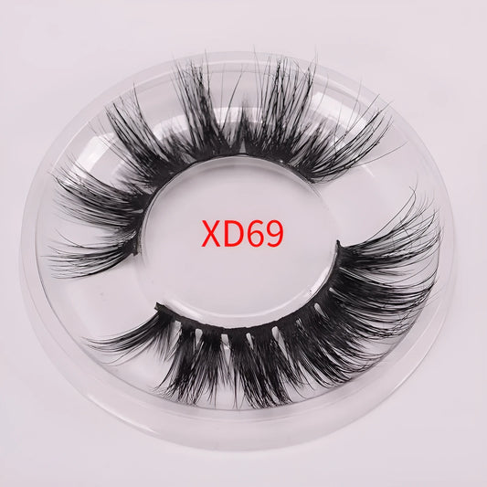 A pair of 5D mink false eyelashes with a hair storage cap and double-ended brush on a pink background.