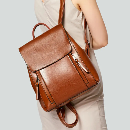 Genuine leather women's backpack with multiple compartments showing stitching details and cover-type opening