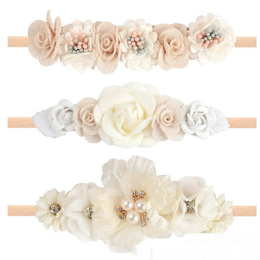 Three identical cloth flower hair bands for children in floral design with soft material construction