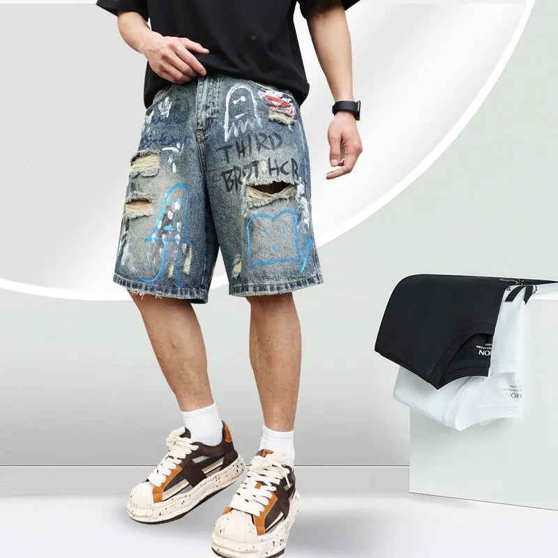 Blue denim men's shorts with ripped knees and graffiti design, featuring a straight leg and zipper fly.