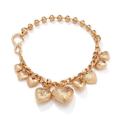 Gold carved heart pendant necklace on adjustable chain, showing exaggerated shape and textured details