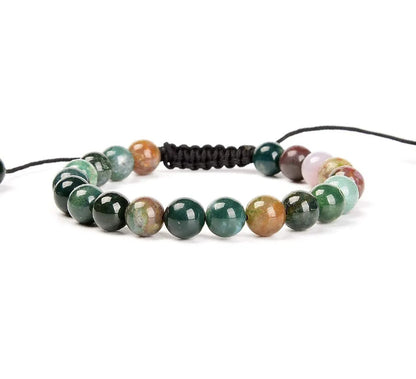 Close-up of a women's flat knot braided healing bracelet hand-woven with colourful gemstones.