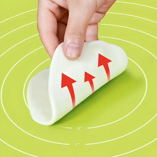 Green antibacterial silicone kneading mat with noodle cutter and rolling pin on kitchen counter