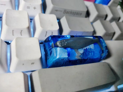 Close-up of a custom resin keycap featuring a detailed blue and orange koi fish scene, designed for Cherry MX mechanical keyboards.