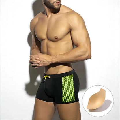 Men's yellow and black polka dot print swimming boxers on a plain background
