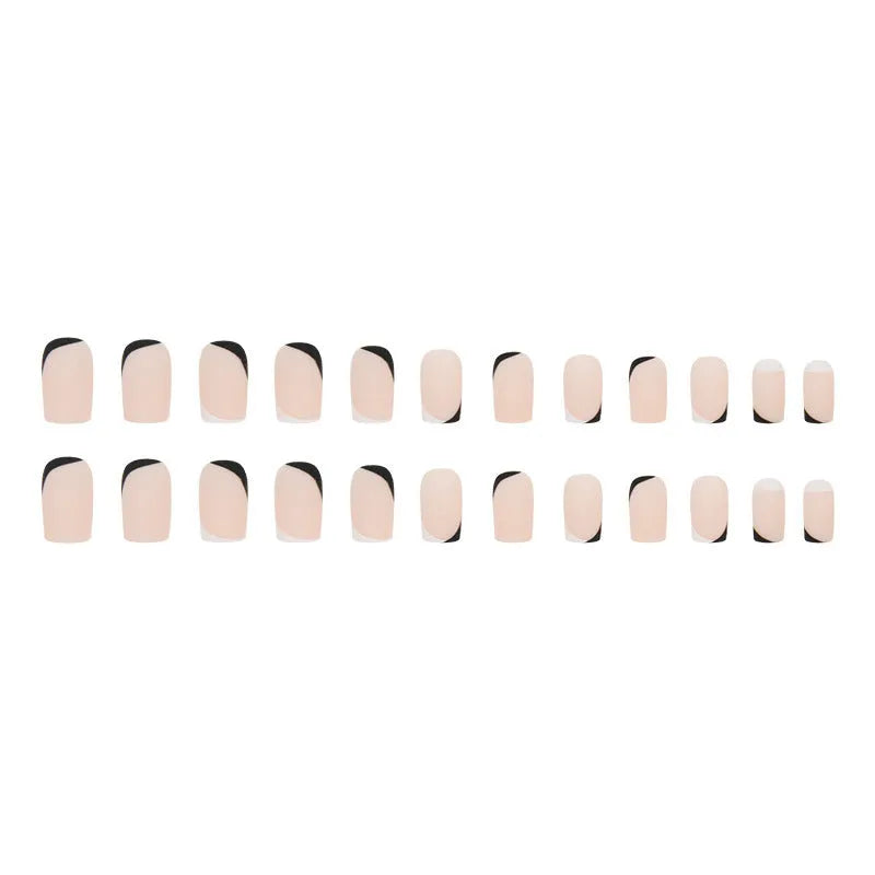 Set of 24 black and white frosted French tip fake nails with matte finish, laid out in size order.