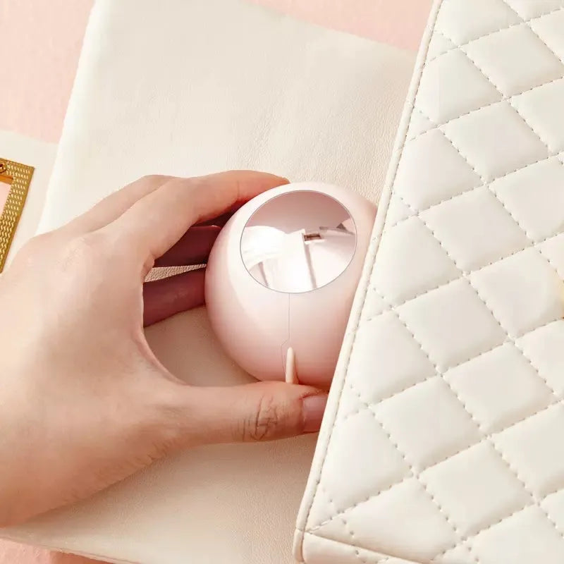 White, pink, green, and deep pink coloured ABS hair removal ball with a handle for pet hair and lint.
