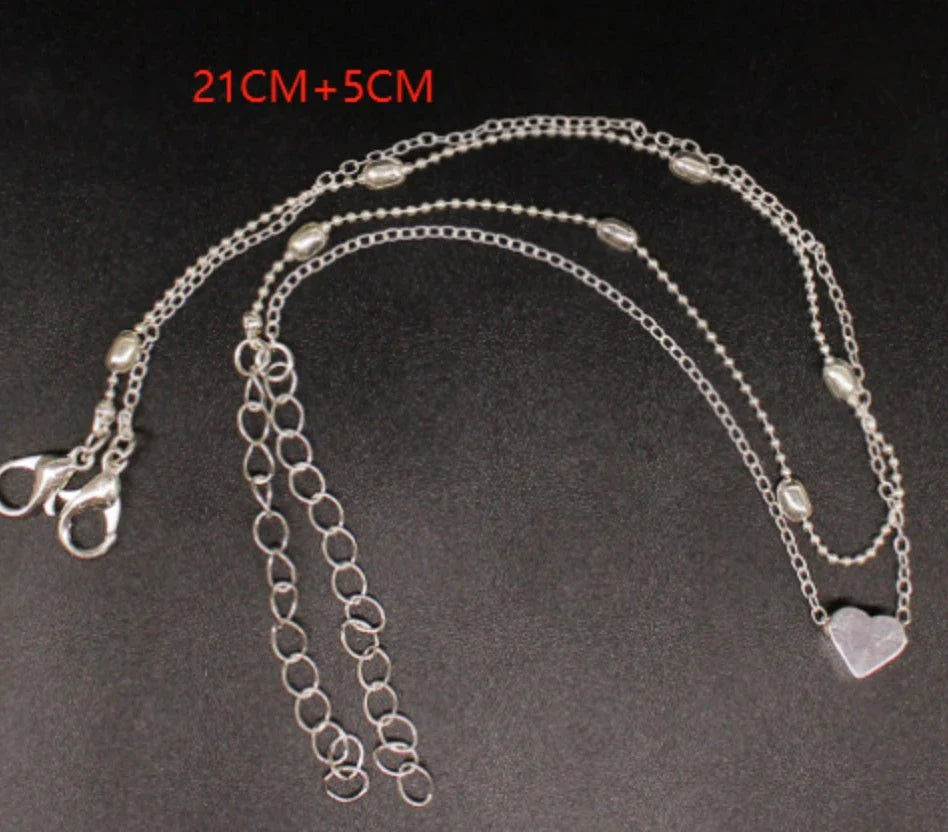 Trendy heart-shaped anklet with double-layered design and retro beach ball chain in gold, silver, and silvery colors.