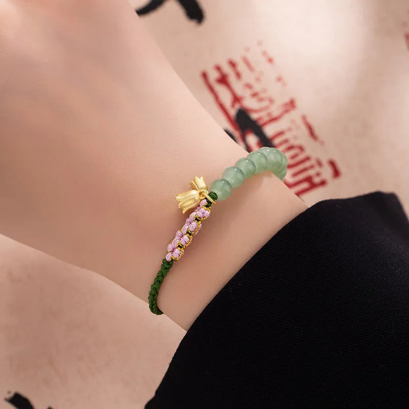 Hand woven red rope women's bracelet in Lily Carrying Strap colour with a flower element.