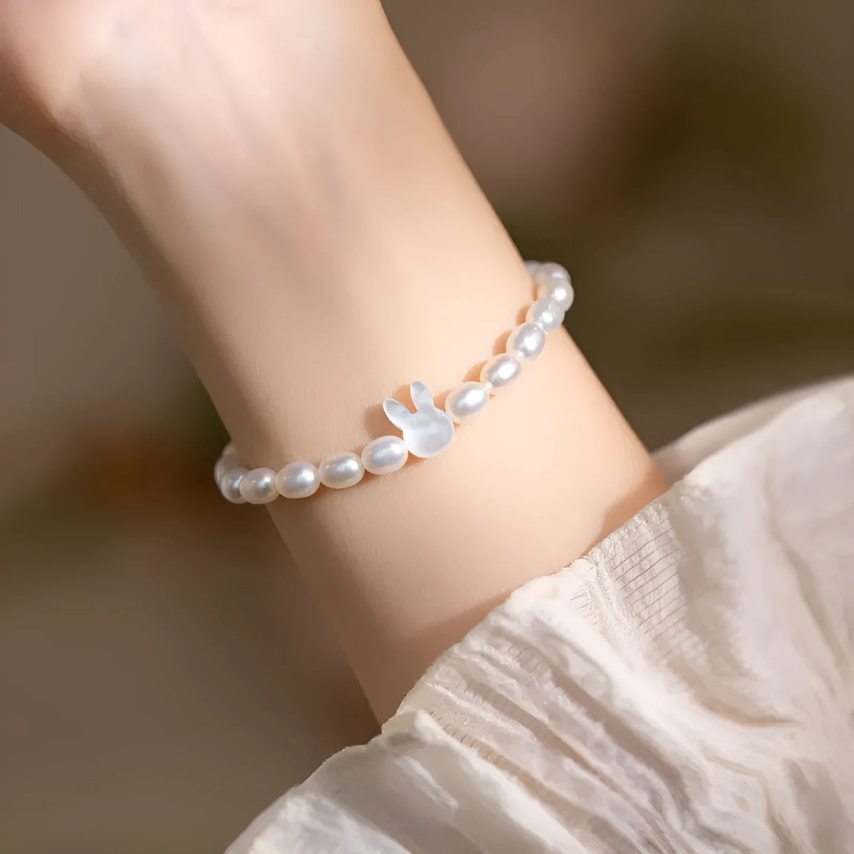 White pearl bead bracelet with silver rabbit charm on elastic string