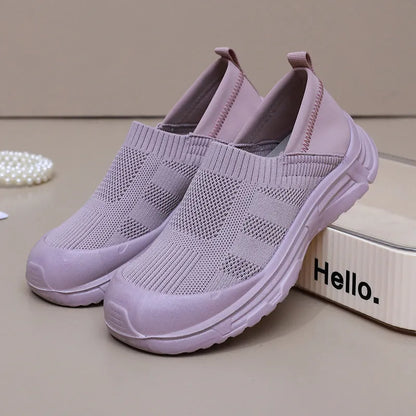 Women's one pedal slip-on shoe in black with cloth upper and PVC sole, showing round toe and flat heel design.