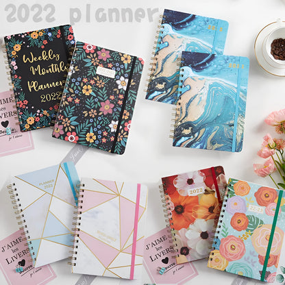 A5 spiral coil notebook open showing annual calendar pages and spiral binding