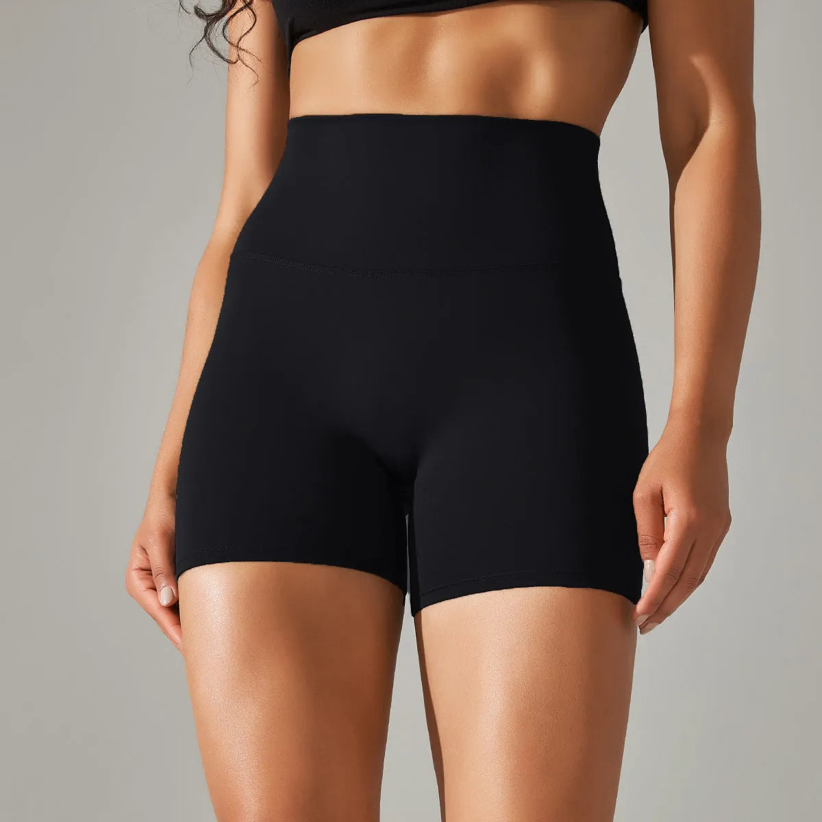 Woman wearing high waist hip lift fitness tights in a neutral colour, suitable for running or gym workout.