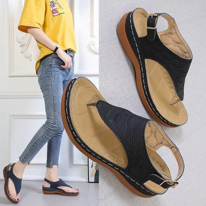 Women's wedge heel flip flop sandals in black with adjustable back strap on a light background