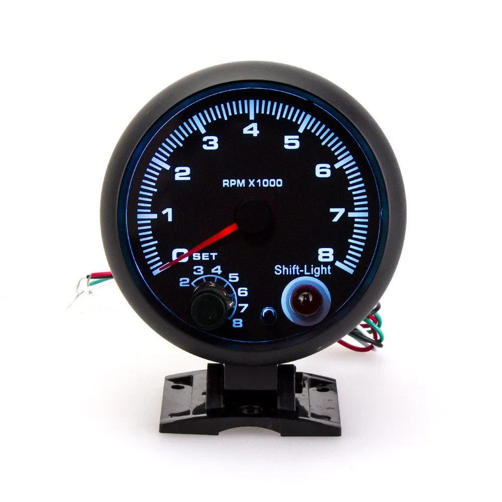 Black automotive tachometer with blue light pointer showing 0-8000 RPM scale.