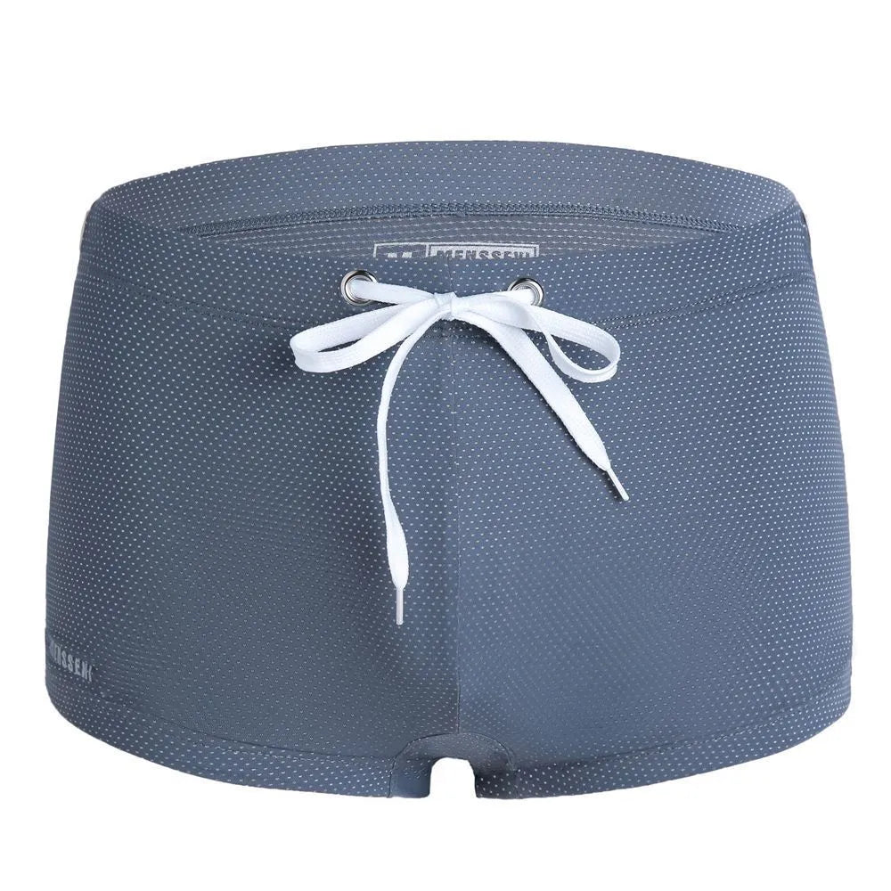 Men's low waist boxer style swimming trunks in nylon, available in multiple solid colours.