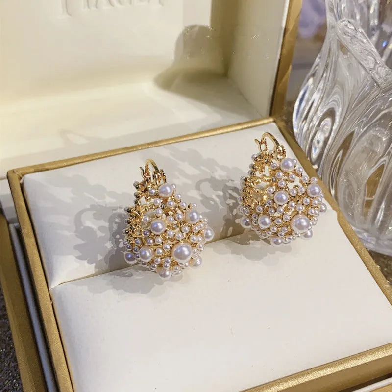 Gold-colour copper flower basket earrings with small rice-shaped bead inlay detail.