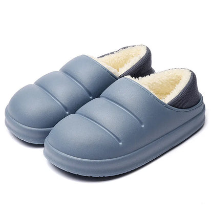 Yellow women's winter slippers with waterproof EVA sole and plush lining on a wooden floor.