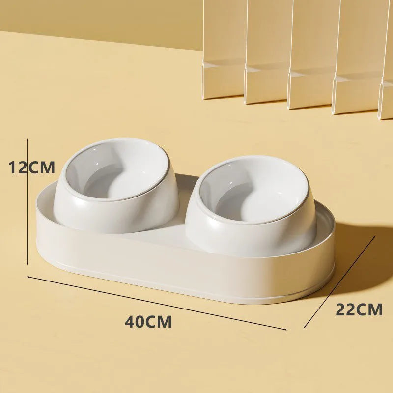White elevated pet double bowl feeder with tilted food and water bowls on a non-slip stand.