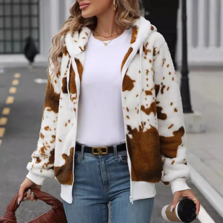 Yellow brown cow print hooded cardigan jacket with zip front and plush texture on a hanger.