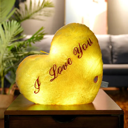 Colourful glowing five-pointed star plush pillow on a dark background.