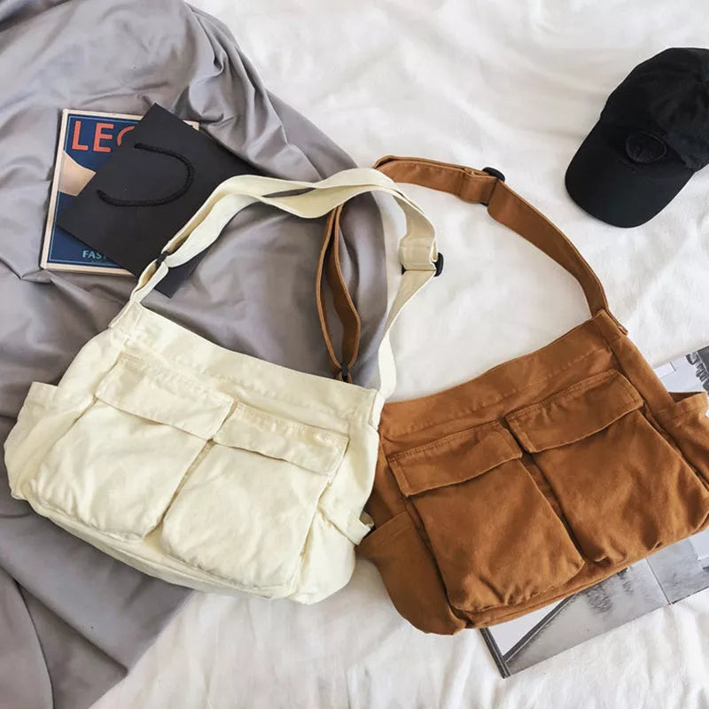 Canvas messenger bag in black, white, green, and brown with multiple pockets and adjustable strap