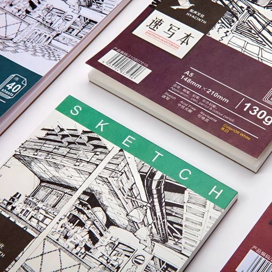 A4 artist sketchbook with spiral coil binding open on a table, showing heavy weight drawing paper.