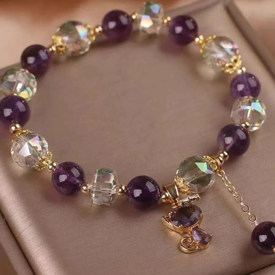 Natural purple amethyst crystal bracelet with nine-tailed fox and flower pendants on wrist.