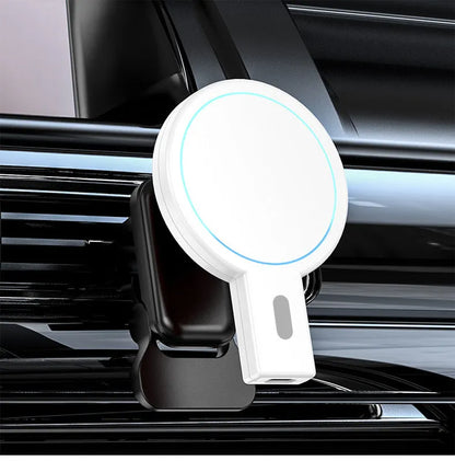 White and black magnetic wireless charging pad on a wooden desk next to a smartphone.