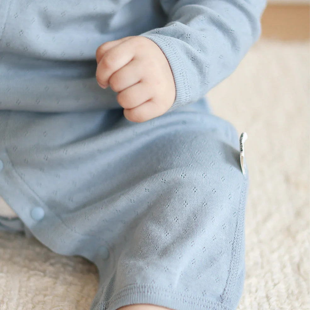 Pure cotton baby romper in blue with long sleeves and single-breasted closure, showing long climbing style design