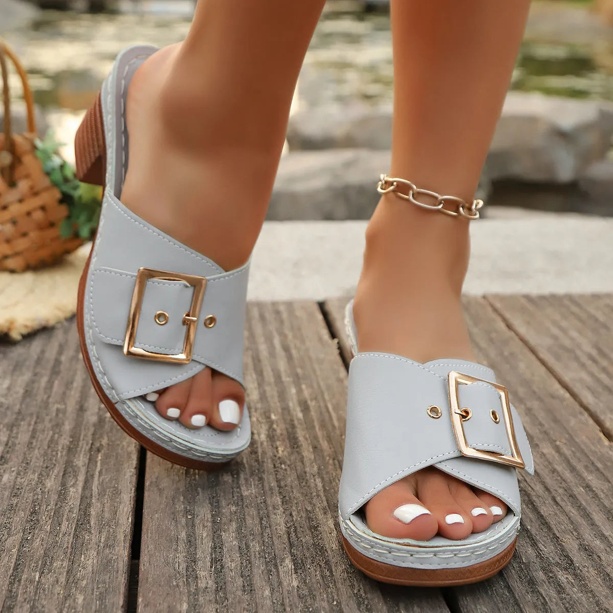 Women's black chunky heel slippers with a metal buckle on the strap and a rubber sole.