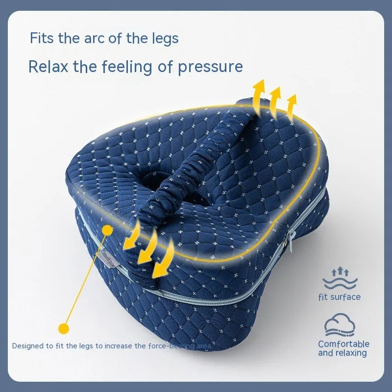 Dark blue jacquard heart-shaped memory foam leg pillow for adults on a bed.