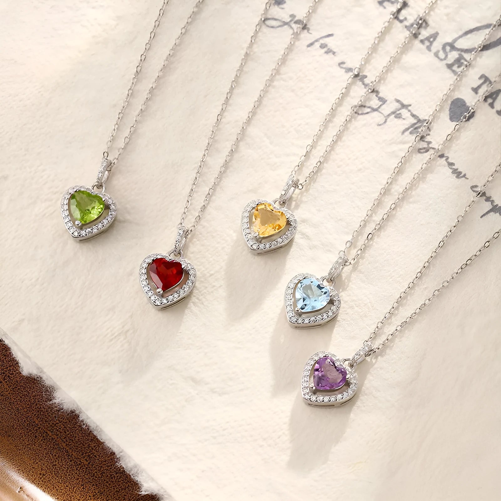 Sterling silver heart pendant necklace with a coloured gemstone on an adjustable chain.