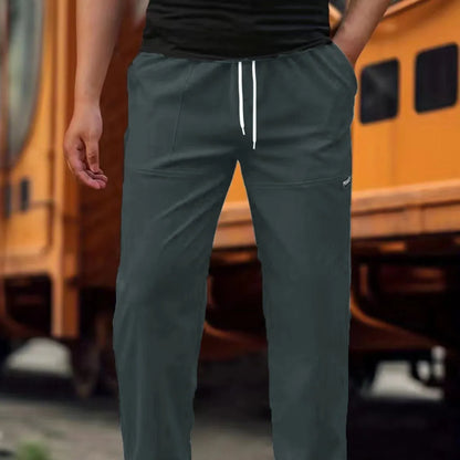 Men's polyester trousers for spring and autumn in light grey, shown in a casual setting