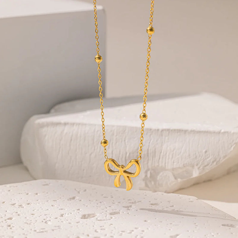 Titanium steel cross chain necklace with a gold-plated bow pendant, offering an adjustable length from 41cm to 50cm for versatile fashion styling.