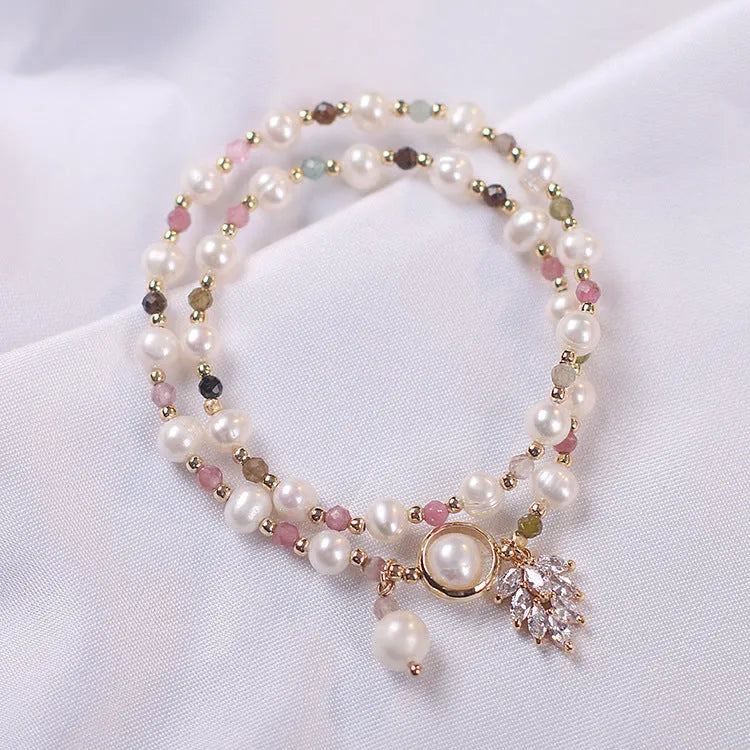 Double-layer strawberry quartz crystal bracelet with lucky cat charm and red cat's eye flowers design.