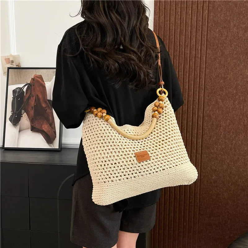 Large brown knitted bucket tote beach bag with contrast stitching and a zip internal compartment.