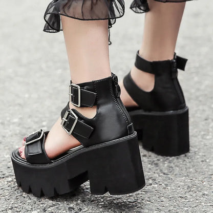 Black women's punk platform sandals with chunky heel, round toe, buckle detail, and back zipper.