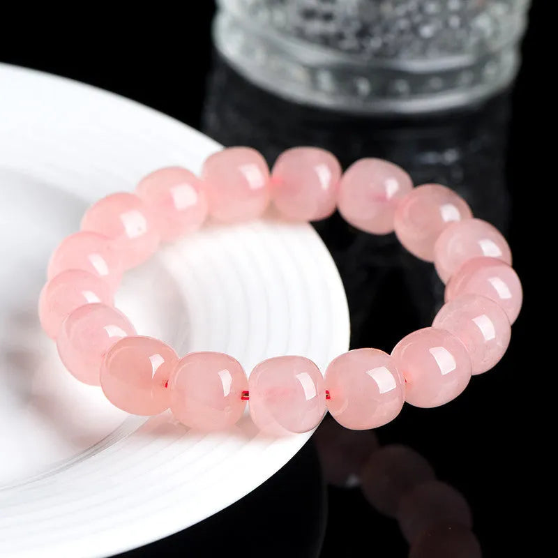 Natural crystal barrel shaped bead bracelet with 19 pink 8-10mm polished crystal beads in geometric pattern