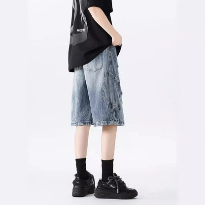 Man wearing loose fit black ripped denim shorts with distressed detailing and a washed vintage finish.