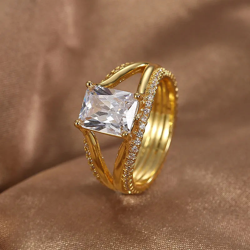 Gold electroplated geometric ring with a square zircon stone on a copper band.