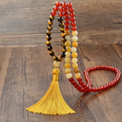 Long beaded necklace with geometric pendant and natural stone tassels in green aventurine.
