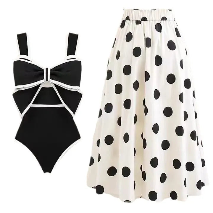 Women's black one-piece swimsuit with white skirt and bow detail for beach swimming