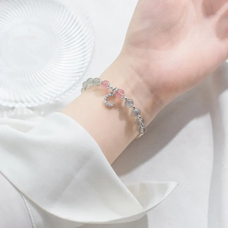 Natural moonlight-coloured moonstone bracelet with silver crescent moon charm on adjustable chain.