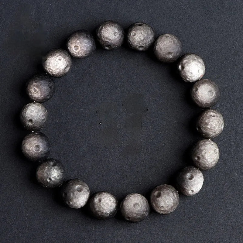 Natural obsidian crater ball bracelet with grinding treatment showing smooth bead texture in silver or golden meteorite colours