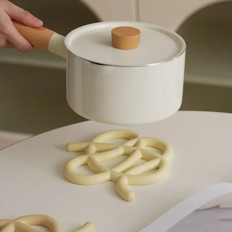 Ceramic heat-proof mat in irregular shape on dining table, protecting surface from hot pot