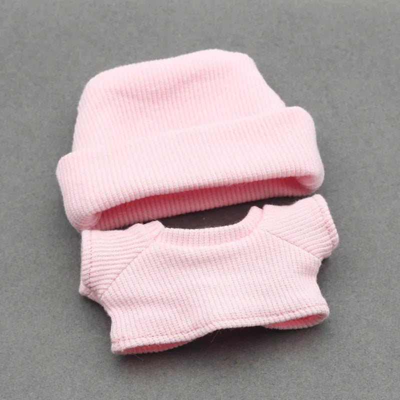 Doll clothes set with knitted flanging hat and T-shirt in multiple colours including pink, white, and stripes.