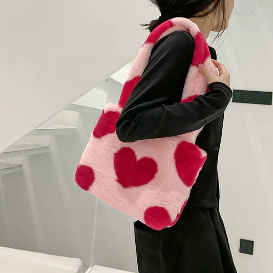 Soft, plush heart-shaped handbag in various vibrant colors with a magnetic closure and interior phone compartment