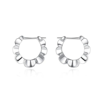 A pair of sterling silver geometric stud earrings with a round centre and butterfly clasp on a grey background.